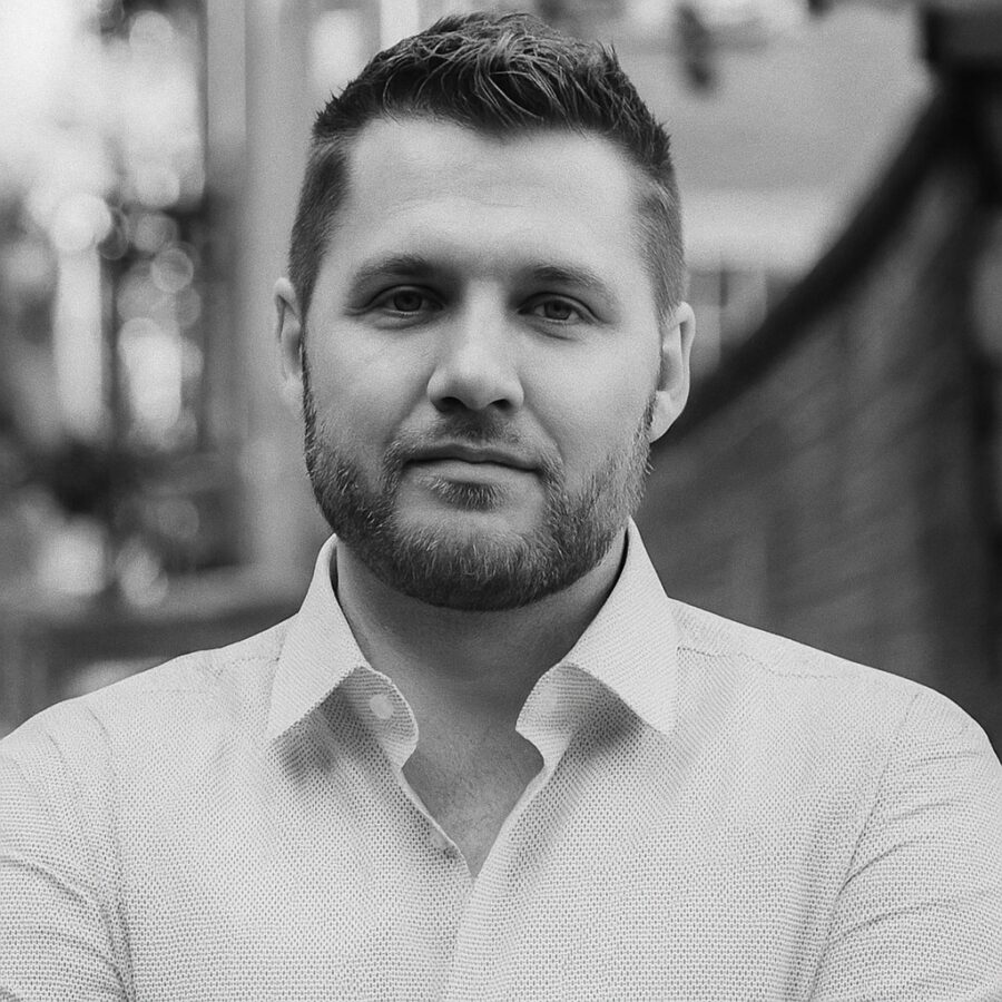 Ritratto in bianco e nero di Mark Manson, autore e blogger statunitense, noto per le sue frasi dirette su responsabilità personale, felicità e crescita emotiva – Il Meglio dei Libri