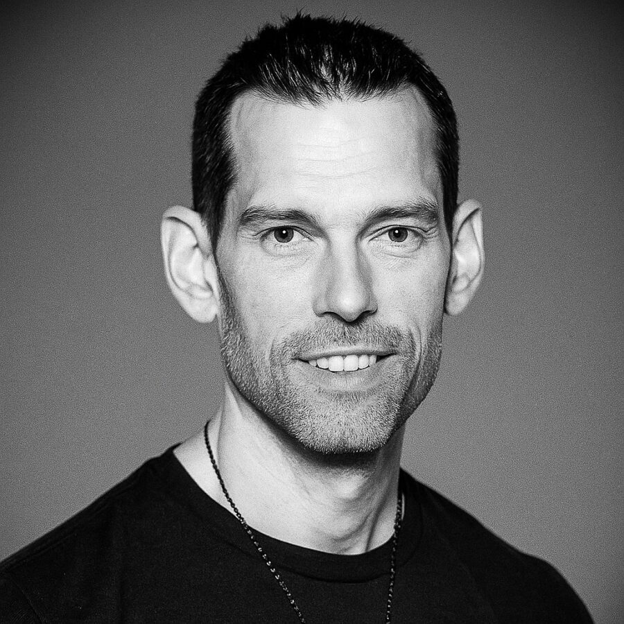 Ritratto in bianco e nero di Tom Bilyeu, imprenditore e speaker motivazionale statunitense, noto per le sue frasi su disciplina, mentalità di crescita e successo personale – Il Meglio dei Libri