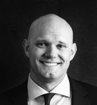 Ritratto in bianco e nero di James Clear, autore e divulgatore americano, noto per il libro Atomic Habits e per le sue frasi su abitudini, miglioramento continuo e crescita personale – Il Meglio dei Libri