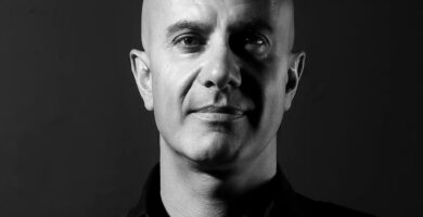 Foto reale di Robin Sharma, scrittore e formatore canadese di fama mondiale, autore de Il monaco che vendette la sua Ferrari, ritratto con espressione serena e sicura, simbolo di leadership, consapevolezza e disciplina personale – Il Meglio dei Libri