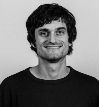 Ritratto in bianco e nero di John Schulman, informatico e ricercatore di intelligenza artificiale, cofondatore di OpenAI, noto per le sue frasi su apprendimento per rinforzo, ricerca e sviluppo dell’AI – Il Meglio dei Libri