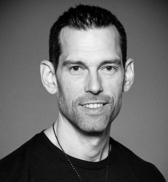 Ritratto in bianco e nero di Tom Bilyeu, imprenditore e speaker motivazionale statunitense, noto per le sue frasi su disciplina, mentalità di crescita e successo personale – Il Meglio dei Libri